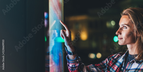 girl pointing finger to blank monitor display, hipster touch multimedia technology on light night city, click media lcd device, mockup screen information gadget photo