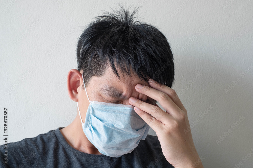 The Face of Sick Asian Chinese Man Wearing Face Mask feeling sick headache and cough because of Coronavirus Covid-19 Isolate on White Background The Face of Sick Asian Chinese Man Wearing Face Mask feeling sick headache and cough because of Coronavirus Covid-19 Isolate on White Background
