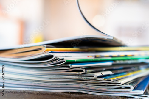 Closeup background of a pile of old magazines with bending pages