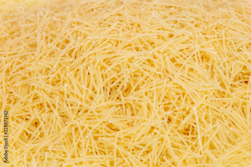 Raw vermicelli pasta (italian pasta) background, close up