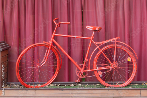 Red bicycle and a background of a fandango color.