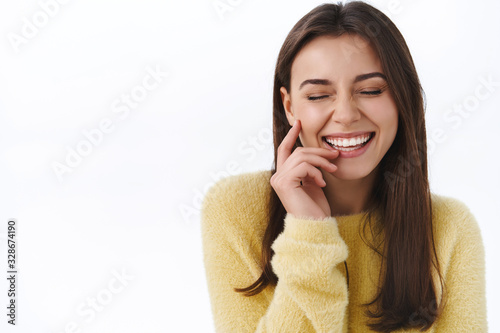 Sincere happiness and emotions concept. Carefree pretty woman laughing silly with closed eyes and true smile, gently touch cheek as having fun, giggle over hilarious joke, white background