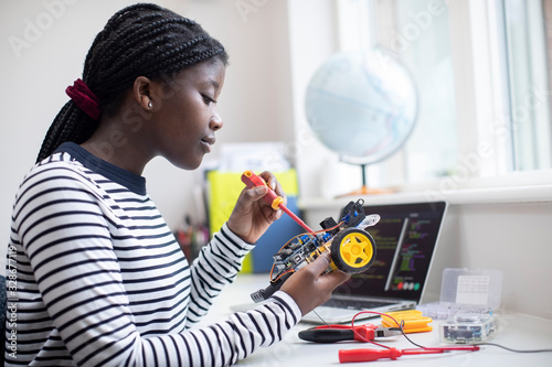 Female Teenage Pupil Building Robot Car In Science Lesson photo