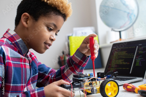 Male Elementary School Pupil Building Robot Car In Science Lesson