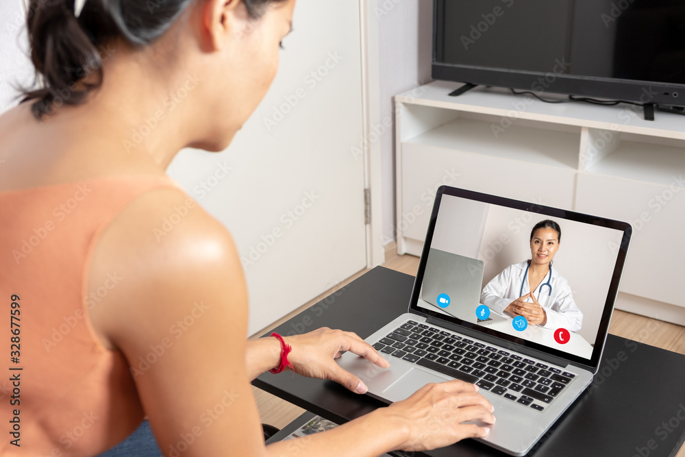 Woman using a laptop for a video call with a doctor Woman using a laptop for a video call with a doctor
