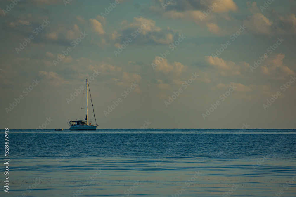 Sunset with a sailing boat on the horizon Sunset with a sailing boat on the horizon