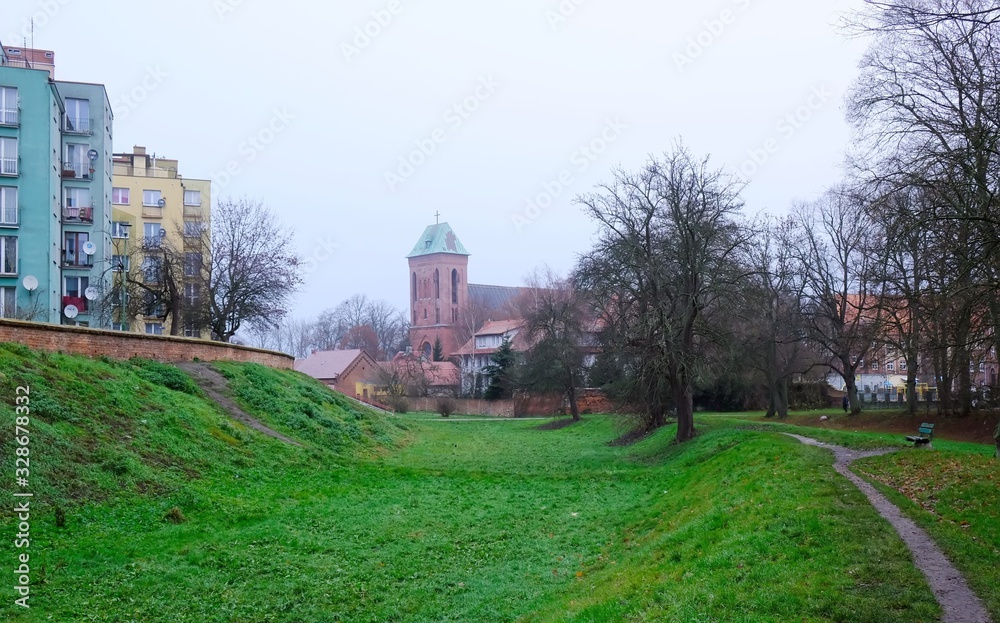 Fototapeta premium Former moat and Co-Cathedral of St. John the Baptist in background in Kamien Pomorski, Poland