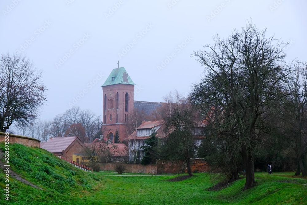 Naklejka premium Former moat and Co-Cathedral of St. John the Baptist in background in Kamien Pomorski, Poland