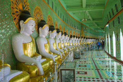 Sculptures of a seated Buddha in the gallery of the cave pagoda U Min Thonze Temple photo