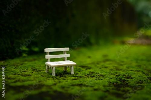 A park bench on green surface with a nice blurry bokeh effect. miniature photography art, light bokeh, photography, background, innovation, energy. © riyas