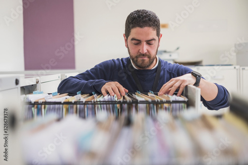 office worker looking files at drawer in office photo