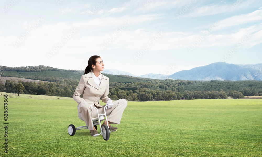 Beautiful young woman riding children's bicycle Beautiful young woman riding children's bicycle