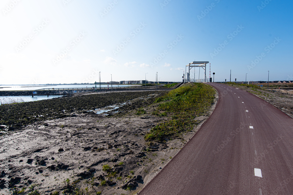a cycle path with a bridge in the background on a sunny day. In Zeewolde Flevoland. March 7, 2020 the Netherlands.