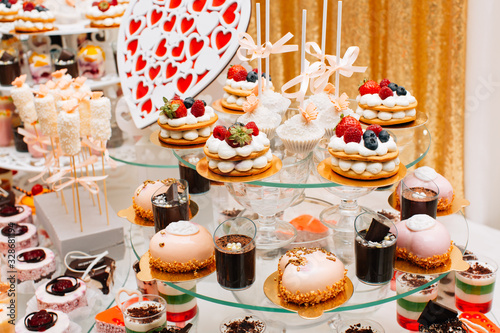 Wedding reception party. Modern desserts, cupcakes, sweets with fruits. Delicious candy bar. Catering Concept.