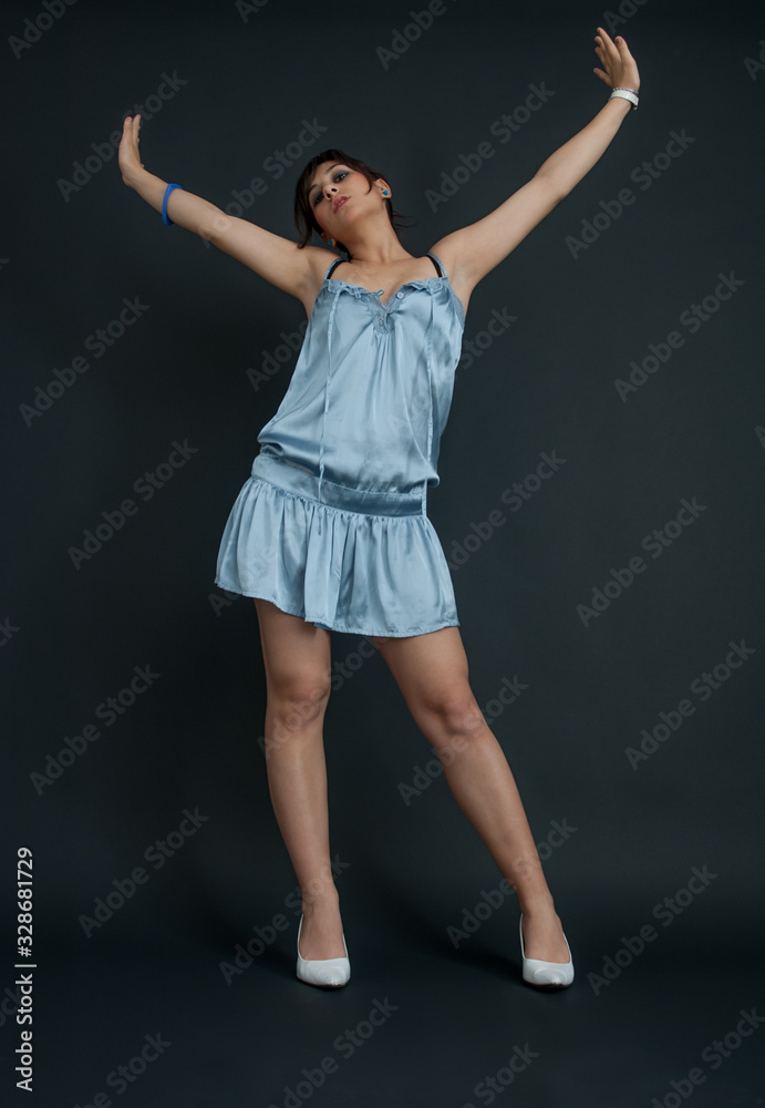 Pretty girl in light blue dress, on black background