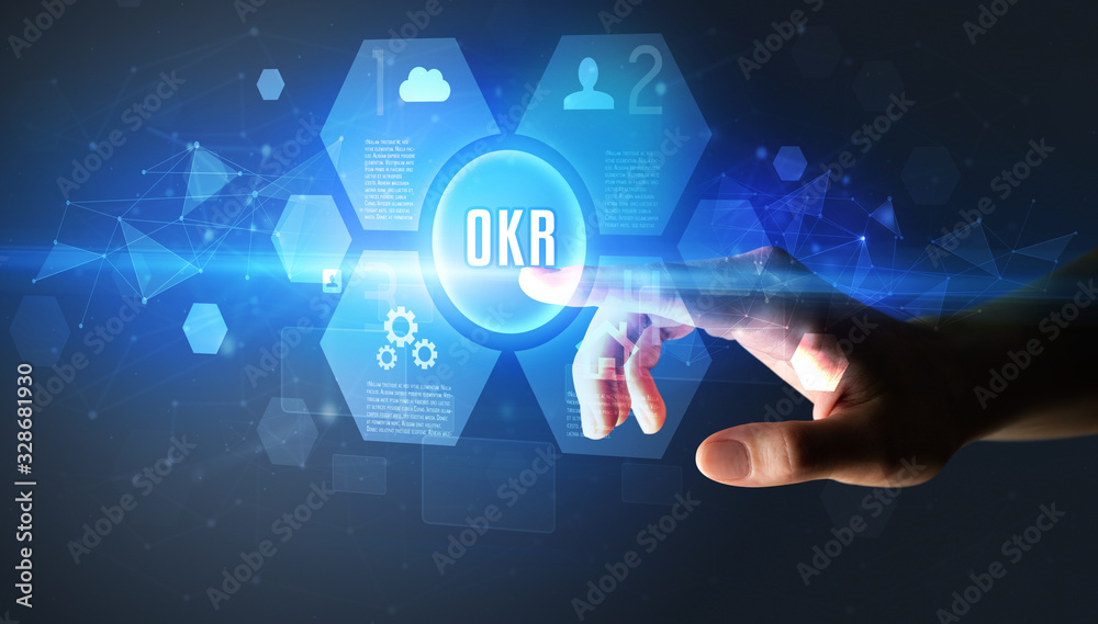 Hand touching OKR inscription, new technology concept Hand touching OKR inscription, new technology concept