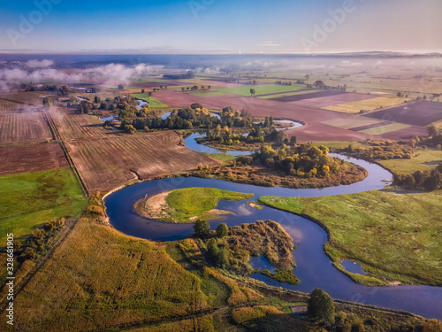 Wijąca się rzeka Gwda wśród pól uprawnych, widok z lotu ptaka photo