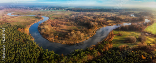 Wijąca się rzeka Warta wśród łąk i lasów Wielkopolski, widok z lotu ptaka