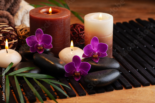 Spa  beauty treatment and wellness background with massage stone  orchid flowers  towels and burning candles.