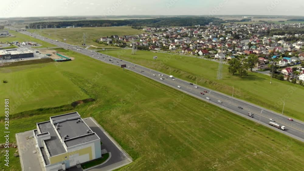 Aerial: panorama of a busy motorway with the private sector in the background. Landscape of the outskirts of the city with a ring road in the summer Aerial: panorama of a busy motorway with the private sector in the background. Landscape of the outskirts of the city with a ring road in the summer