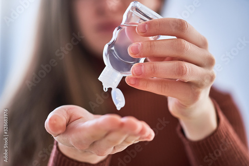 Female applying an antibacterial antiseptic gel for hands disinfection from bacteria. Health protection during flu virus outbreak, epidemic and infectious diseases