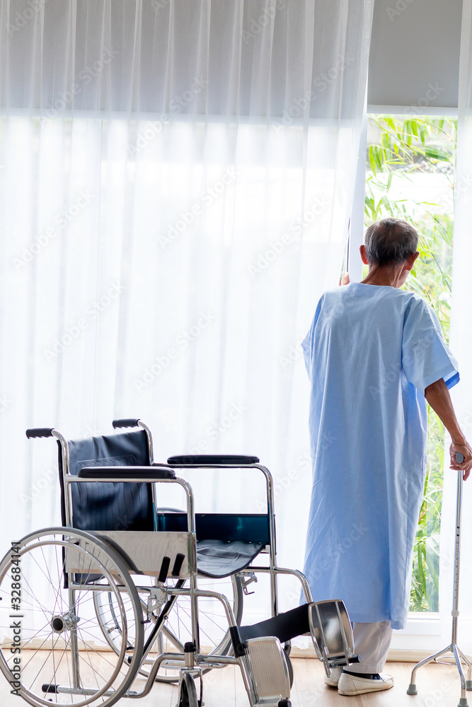 Senior man patient with walking stick in the hospital room.