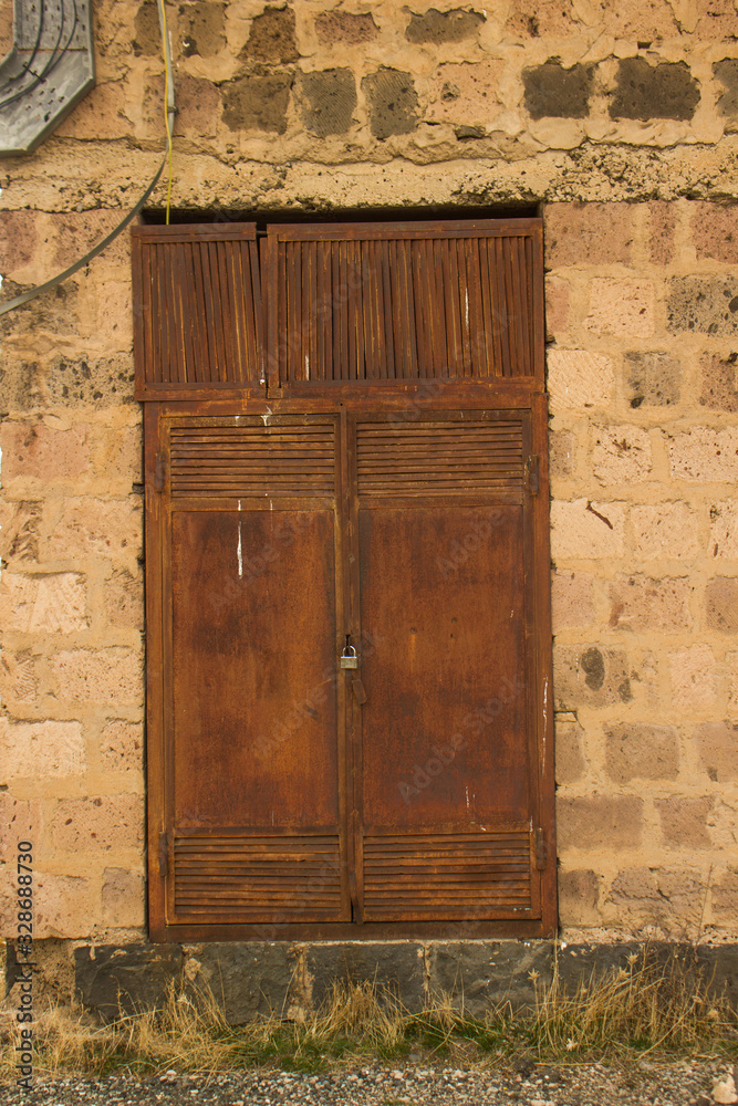 old rusty steel door of secret laboratory in stone wall