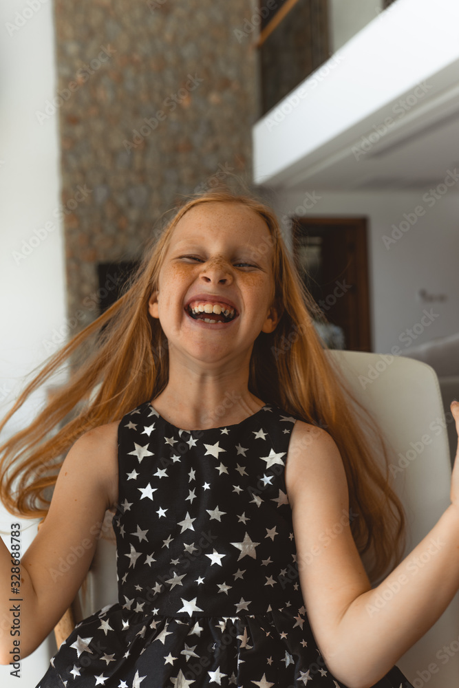 Little girl with red hair shows different emotions. Sadness, joy and happiness. She smiles and cries. In a black dress with skin pigment on her face, freckles Little girl with red hair shows different emotions. Sadness, joy and happiness. She smiles and cries. In a black dress with skin pigment on her face, freckles