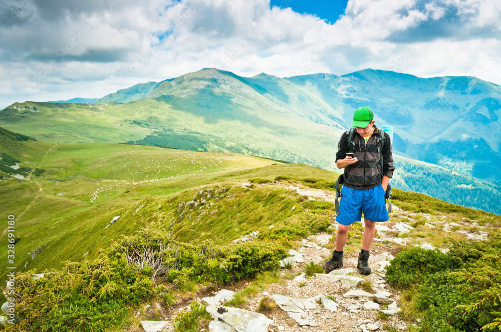 Man using a mobile phone in the mountains, hiking, gps orientation, interactive maps Man using a mobile phone in the mountains, hiking, gps orientation, interactive maps