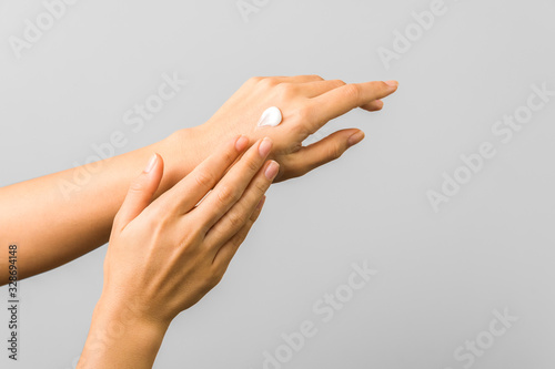 closeup of tender hands of a young woman with moisturizer on. spring skin protection photo