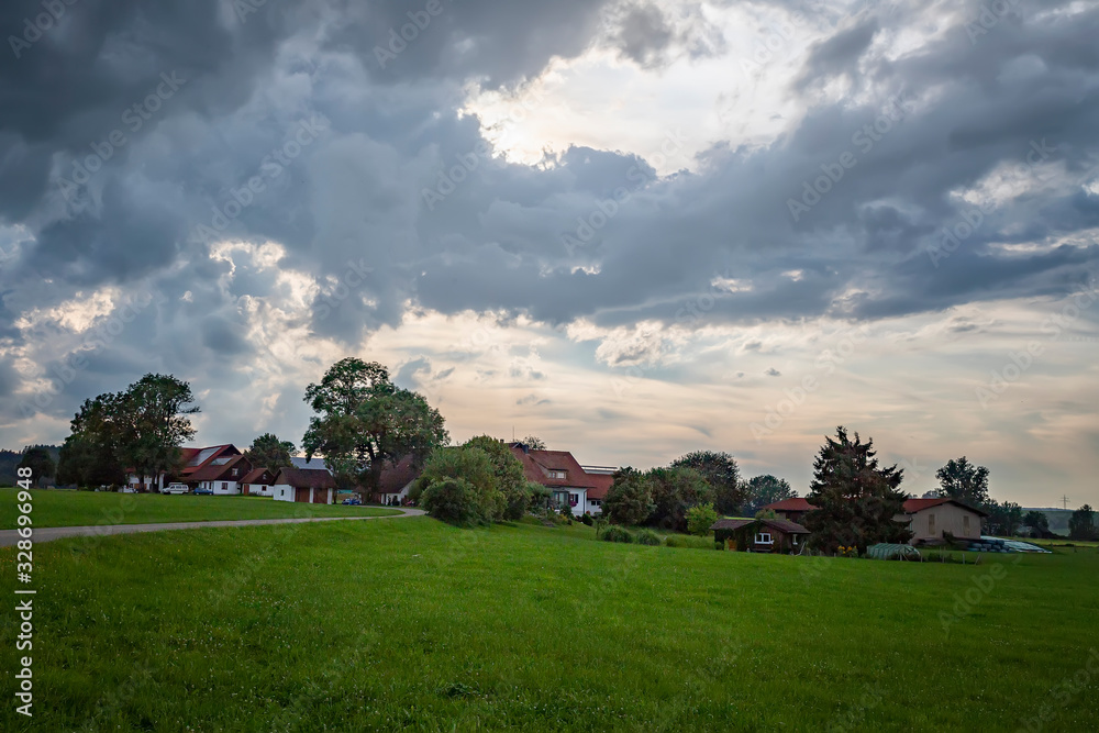 idyllic landscape with greenfield, road, and traditional german farmhouses.