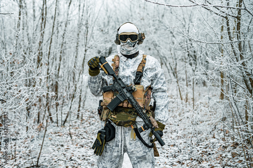 Fotografie Military man in white camouflage uniform with machinegun