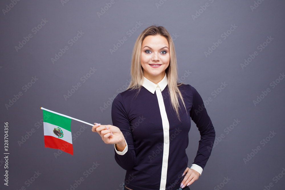 Immigration and the study of foreign languages, concept. A young smiling woman with a Mexico flag in her hand. Immigration and the study of foreign languages, concept. A young smiling woman with a Mexico flag in her hand.