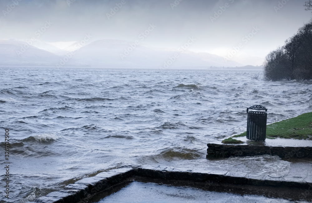 Water flood at lake rough water waves over park Scotland uk Water flood at lake rough water waves over park Scotland uk