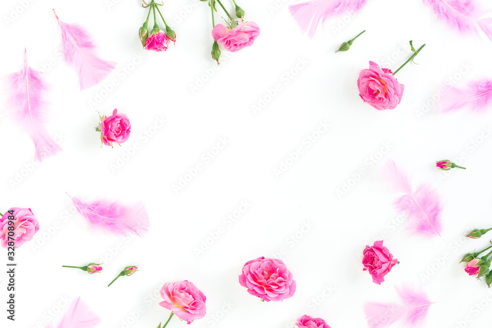 Floral frame with pink roses flowers and feathers on white background. Flat lay