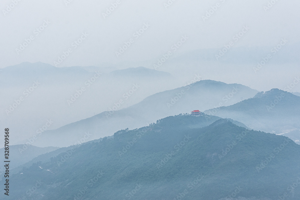 The hazy scenery of the mountain peak filled with clouds