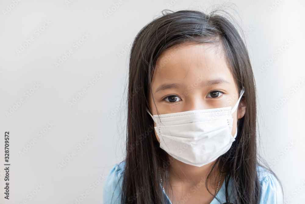 Asian girl wearing surgical mask to prevent PM2.5 air pollution and virus in year 2020 Asian girl wearing surgical mask to prevent PM2.5 air pollution and virus in year 2020