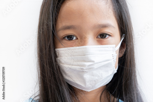 Asian girl wearing surgical mask to prevent PM2.5 air pollution and virus in year 2020