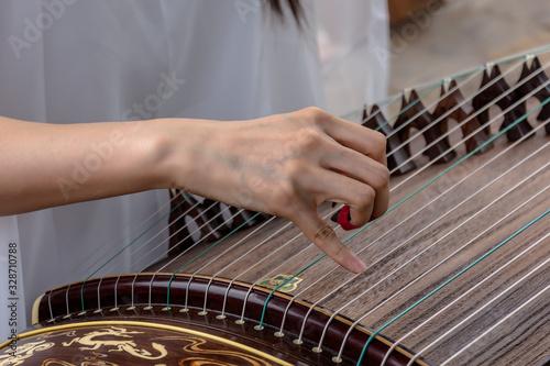 One hand is playing the zither