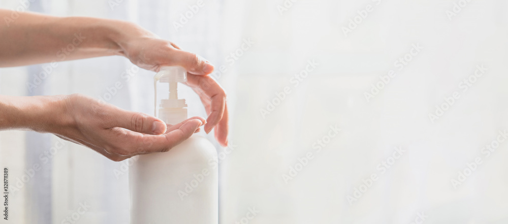 Plakat Woman hands pushing pump plastic soap bottle with copy space, using wash hand sanitizer gel pump dispenser. killing germs, bacteria and virus