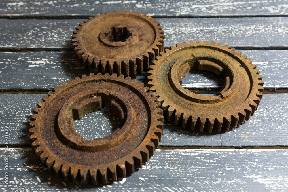 Old rusty gears from machines on a wooden table. Old rusty gears from machines on a wooden table.
