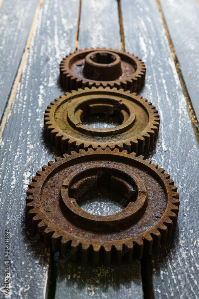 Fototapeta premium Old rusty gears from machines on a wooden table.