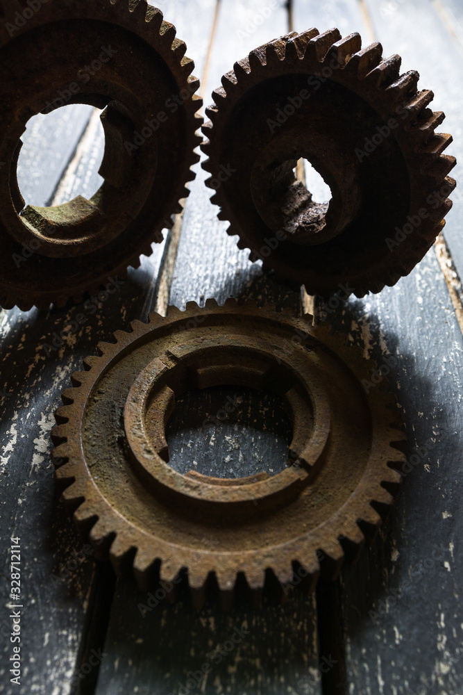 Old rusty gears from machines on a wooden table. Old rusty gears from machines on a wooden table.