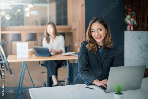 Portrait of young asian businesswoman sitting at her office looking at camera.