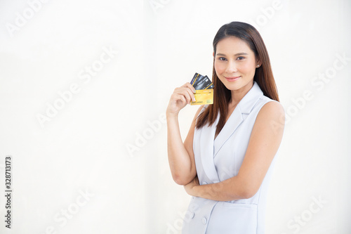 Happy asian woman smile at credit card, hold shopping reward bonus on isolate white background. Student customer people show debit reward for discount payment, travel loan salary dept purchase concept