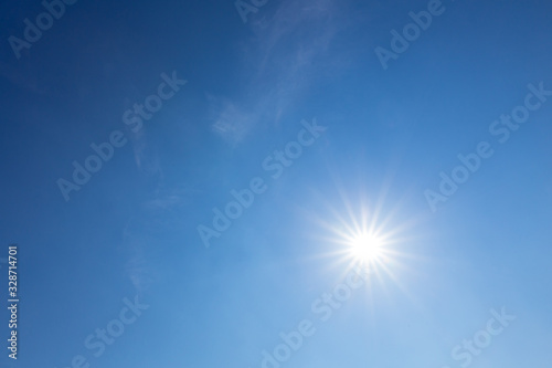 Shining sun on clear blue sky. lens flare of sunlight on blue sky background. Bright sun on blue sky.