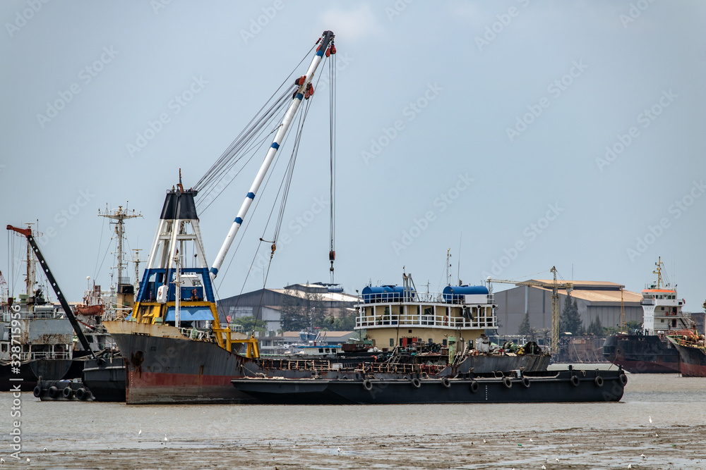 Transhipment of goods between ships on the Chao Phraya River, Samut Prakan Thailand.