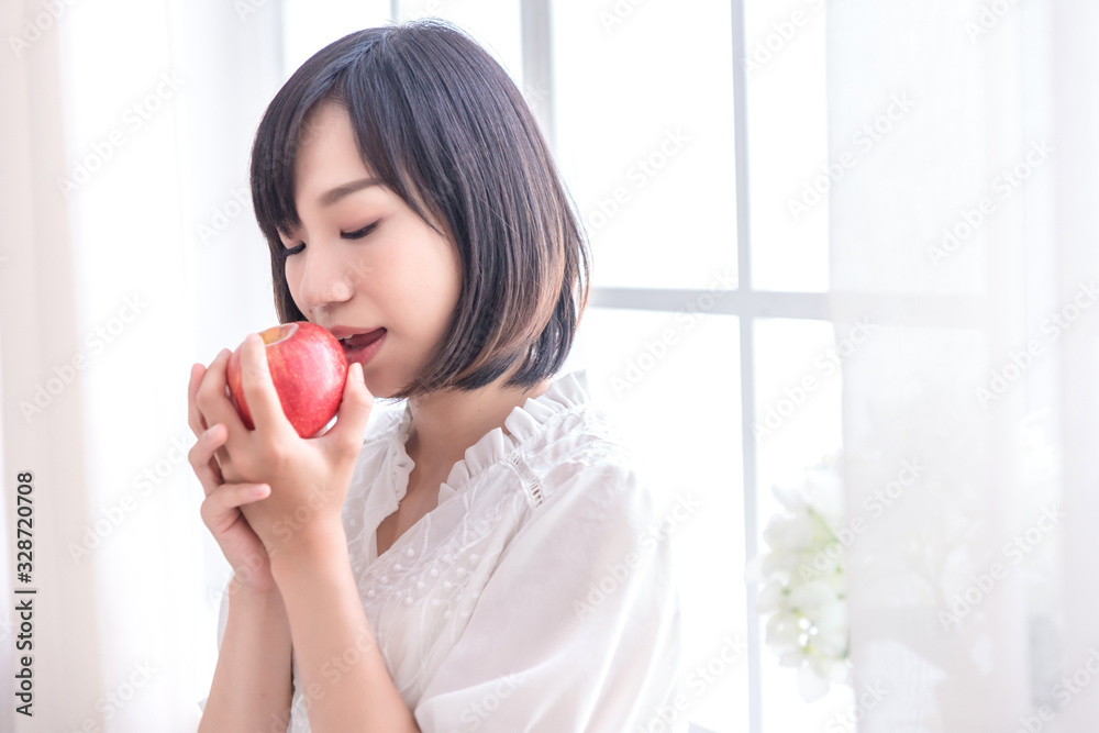 Beautiful Asian girl with apple in house, education or health or startup business concept, modern office or living room with copy space Beautiful Asian girl with apple in house, education or health or startup business concept, modern office or living room with copy space