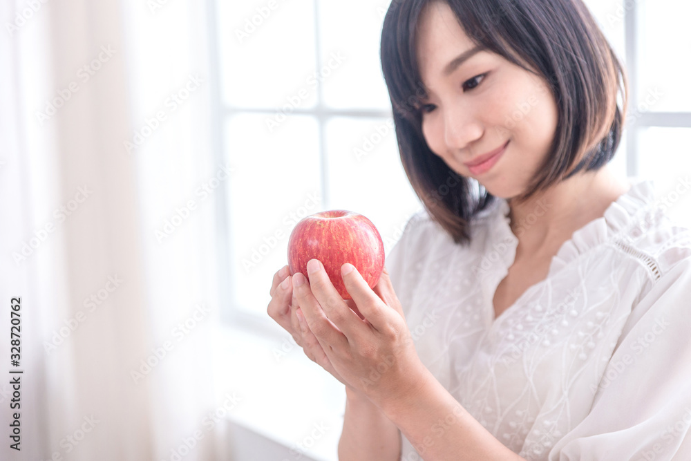 Beautiful Asian girl with apple in house, education or health or startup business concept, modern office or living room with copy space Beautiful Asian girl with apple in house, education or health or startup business concept, modern office or living room with copy space