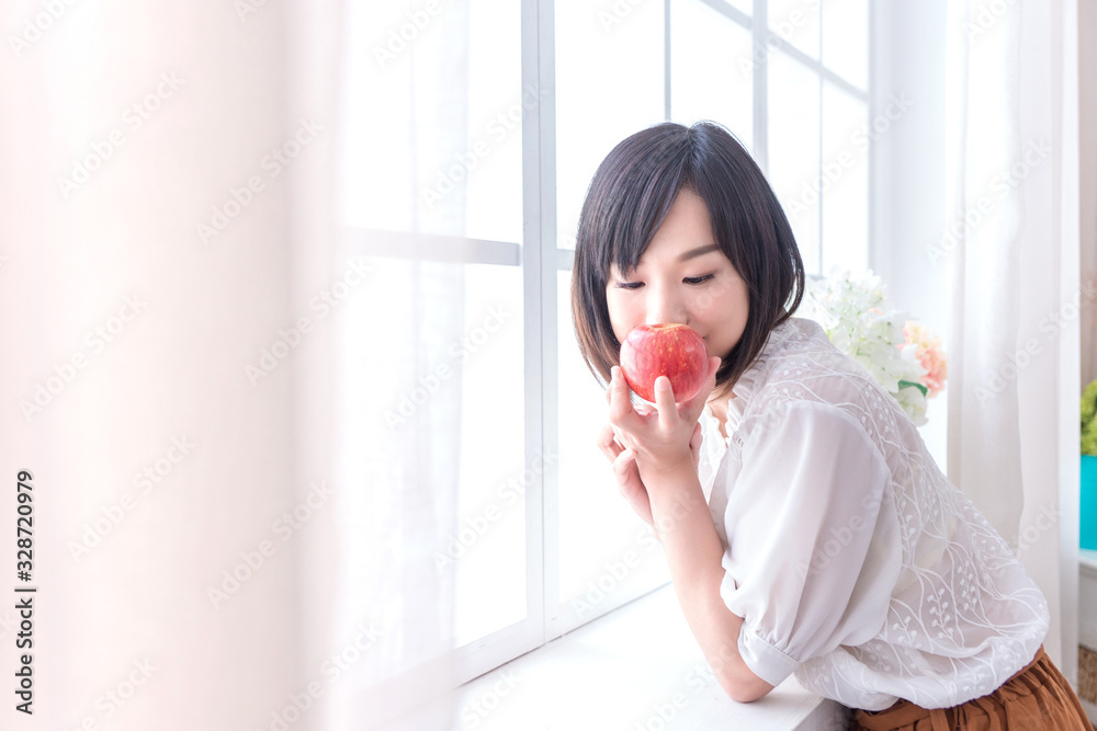 Beautiful Asian girl with apple in house, education or health or startup business concept, modern office or living room with copy space Beautiful Asian girl with apple in house, education or health or startup business concept, modern office or living room with copy space